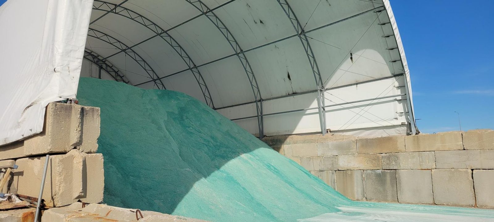Bulk rock salt stockpile under a storage dome